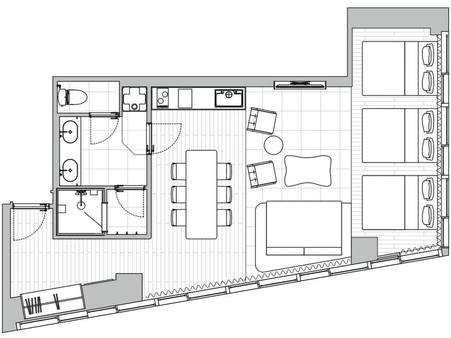 A hotel room layout with a bed, seating area, and kitchenette.
