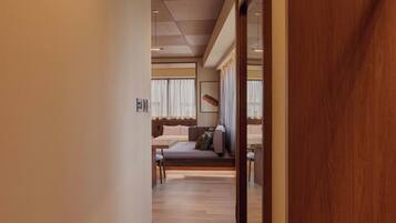 A hotel room with a bed, a desk, and a window with curtains.