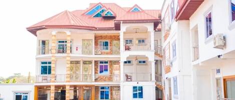 A multi-story hotel with a central courtyard, balconies, and a swimming pool.