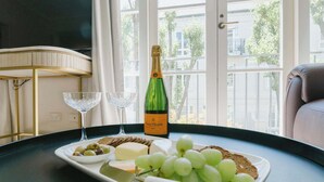 A tray with cheese, grapes, crackers, and a bottle of Veuve Clicquot on a table by a window. - Elegant East Melbourne Escape | Pool+Gym+Parking (East Melbourne)