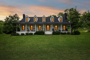 A two-story house with a porch, multiple windows, and a well-maintained lawn.