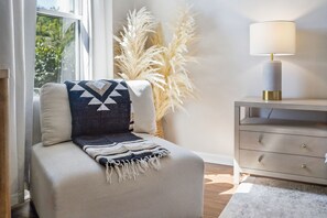 Eine gemütliche Sitzecke mit gepolsterten Sitzbänken, einem Zierkissen und einer Lampe auf einem Nachttisch.