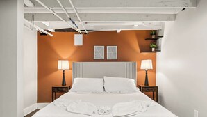 A neatly made bed with white linens, two bedside lamps, and a headboard. - Spacious family-friendly home w/ exclusive arcade! (New Albany)