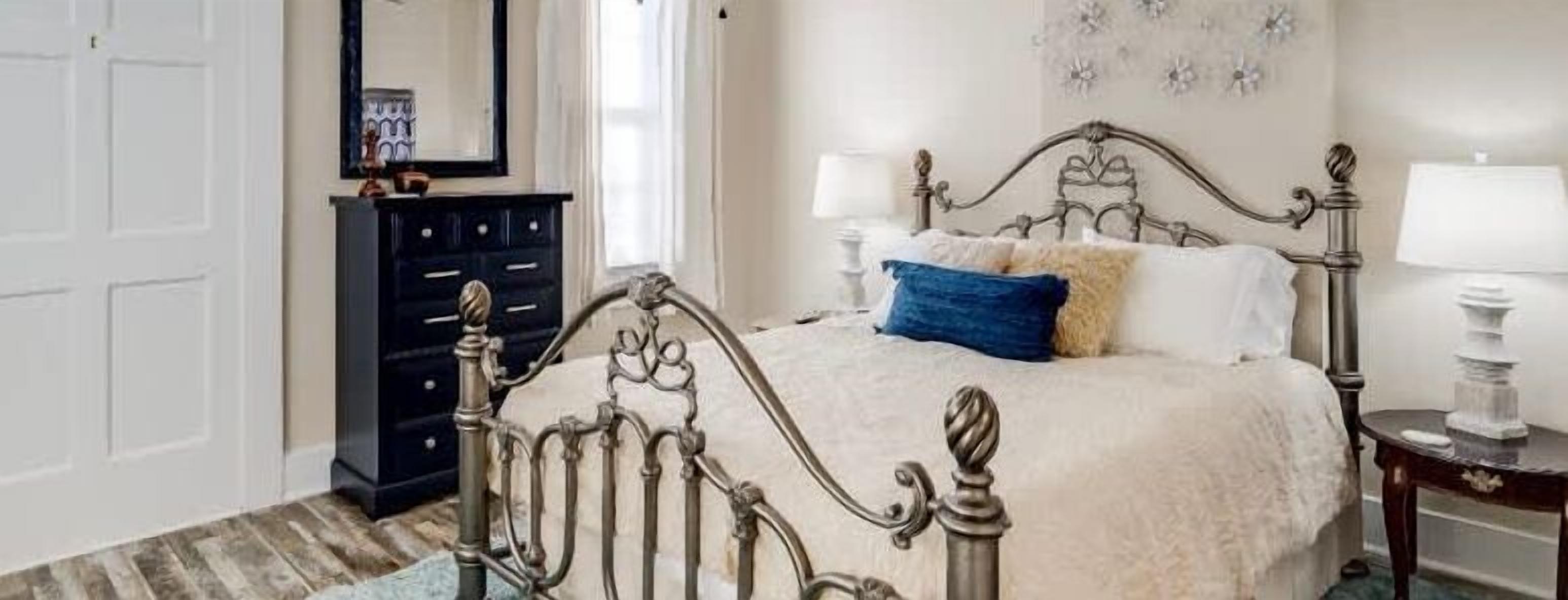 A bedroom with a bed, a dresser, and a nightstand.