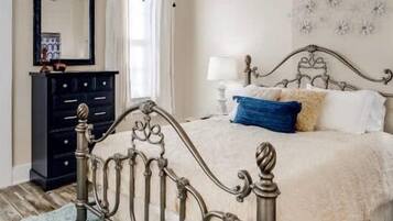 A bedroom with a bed, a dresser, and a nightstand.