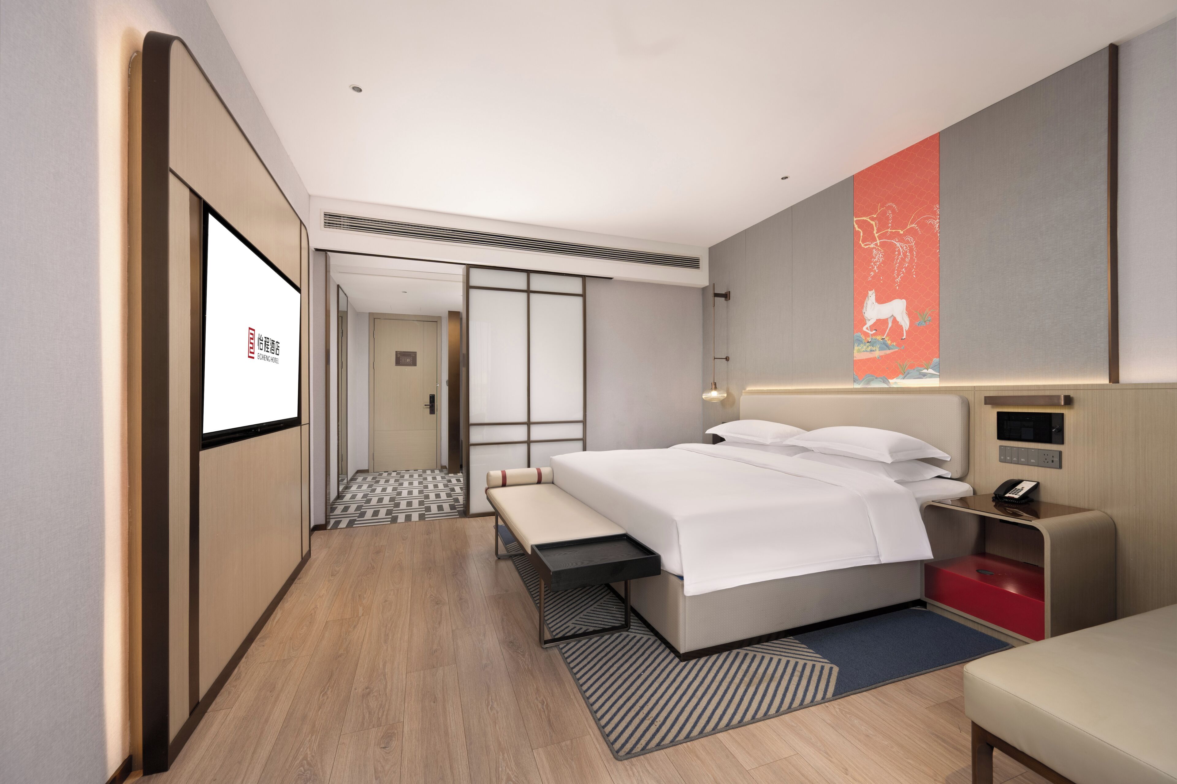 Une chambre d’hôtel moderne, équipée d’un lit, d’une table de chevet et d’une grande fenêtre.