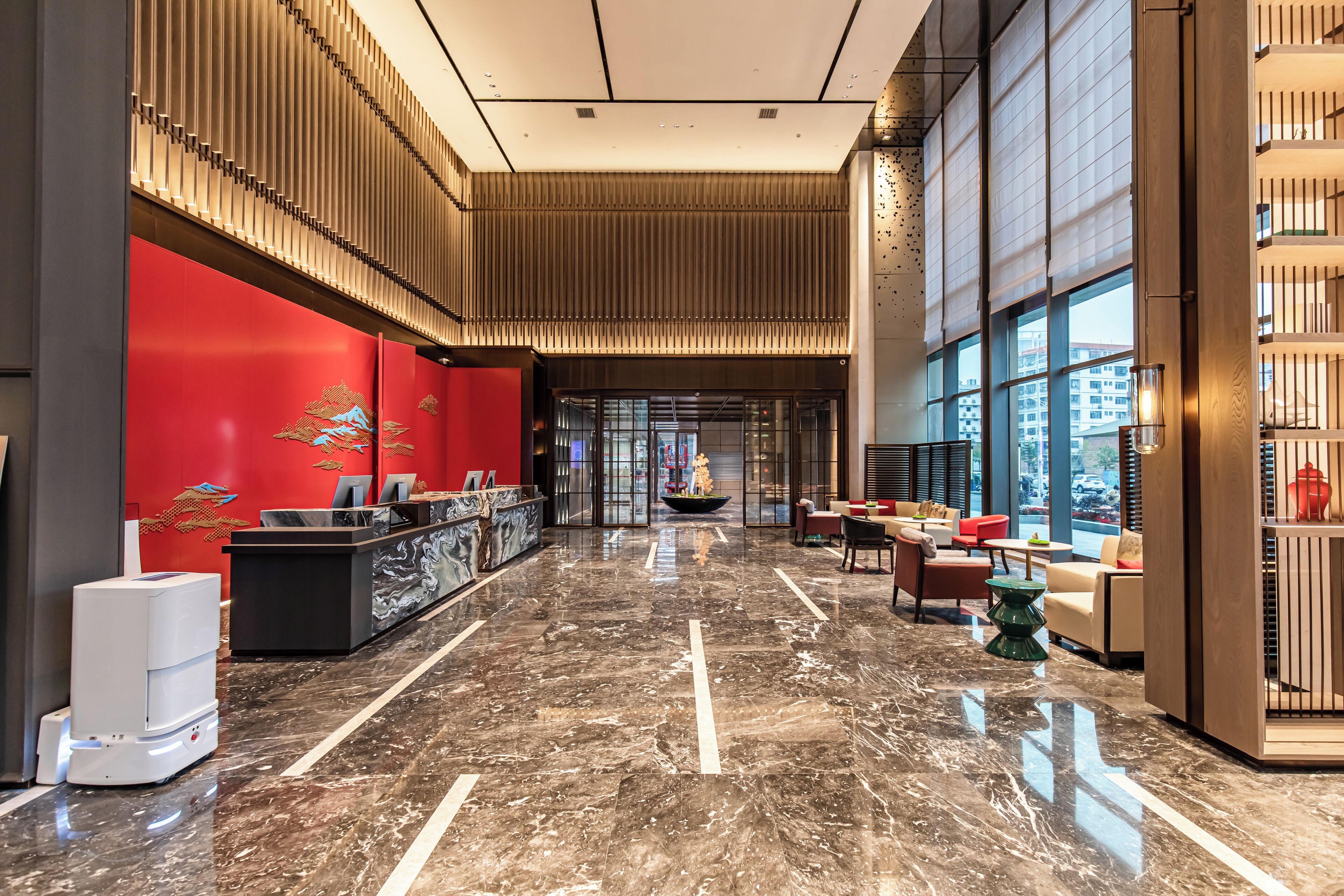 A spacious lobby with a marble floor, a reception desk, and seating areas.