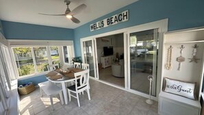 Une pièce bien éclairée, comprenant un coin repas, un ventilateur de plafond et une enseigne indiquant « WELLS BEACH ».