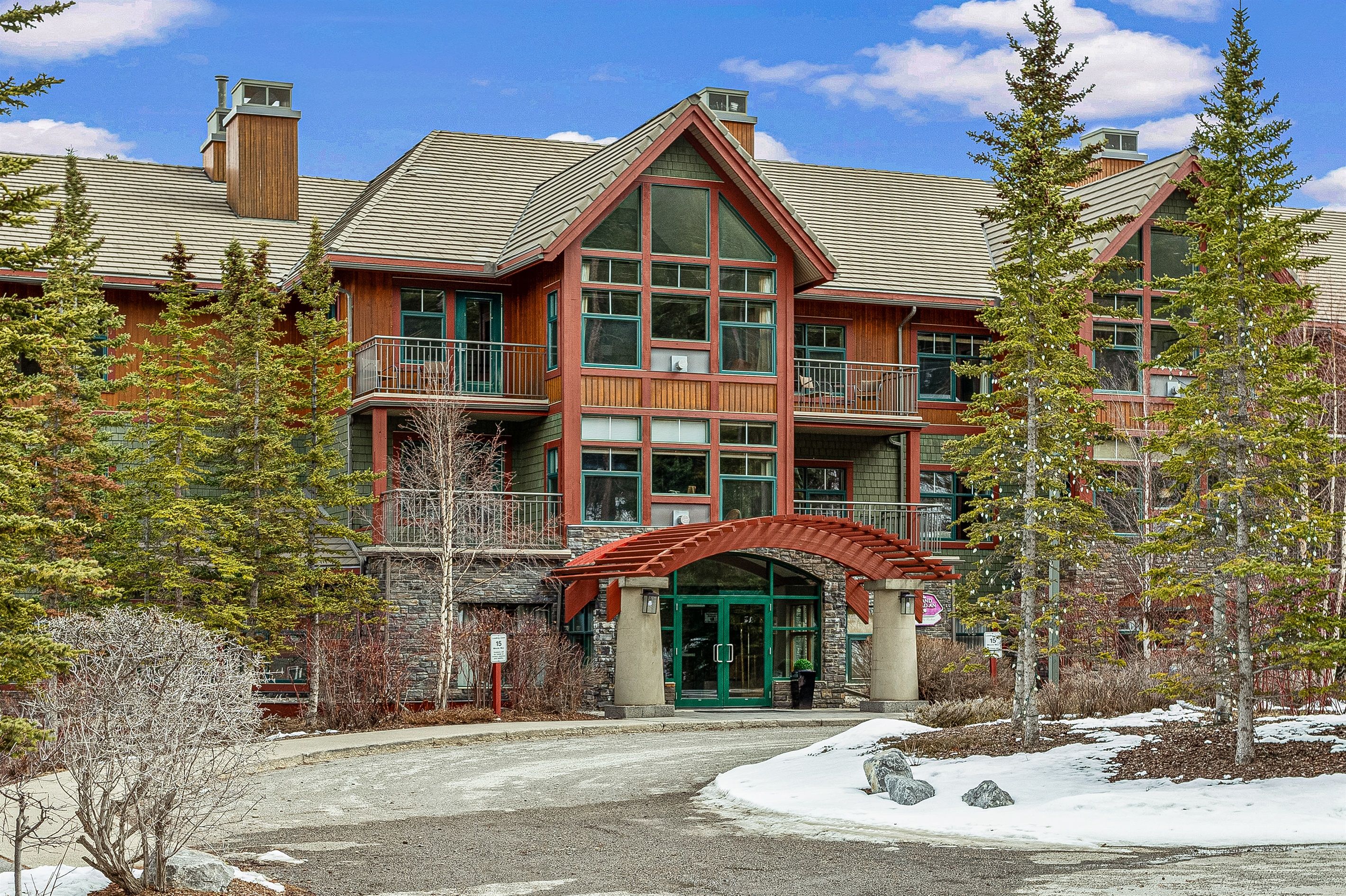 A multi-story lodge with a prominent entrance, large windows, and a balcony on the second floor.
