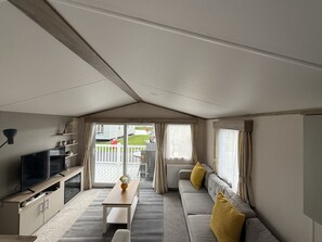 A modern living room with a sofa, a TV, and a dining table.