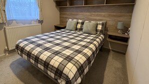 Una camera da letto con un letto, un comodino, una lampada e scaffali a muro in legno.
