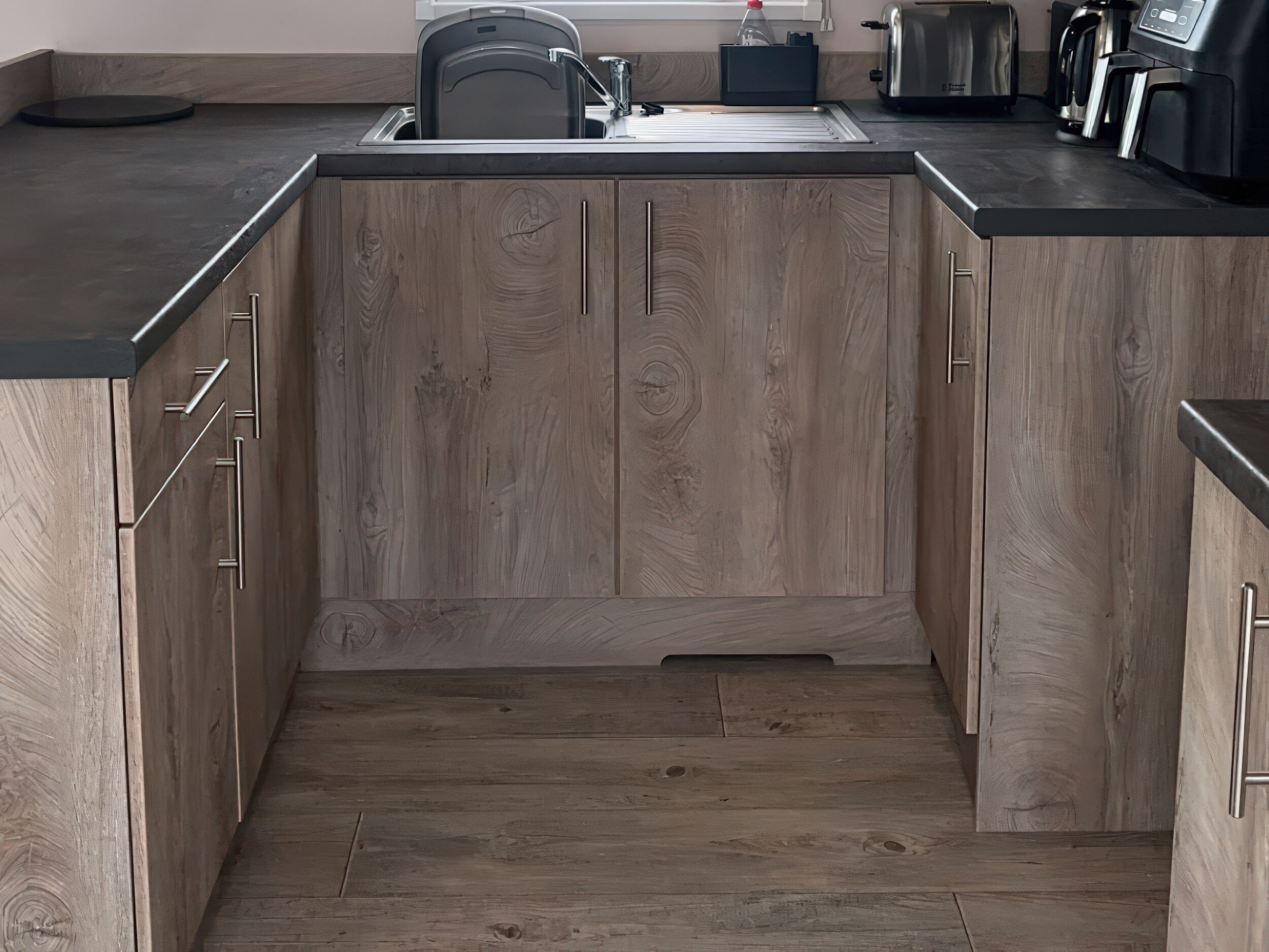 A kitchen with wooden cabinets, a sink, and a countertop.