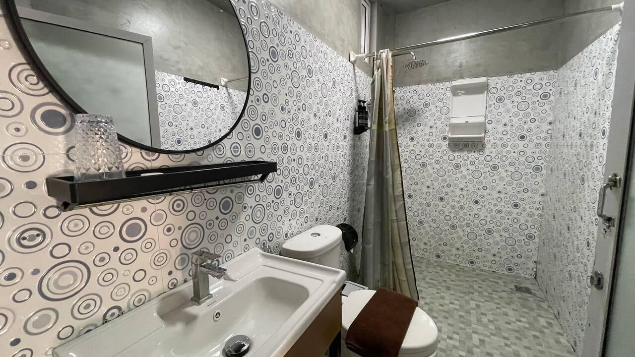 Ein Badezimmer mit Waschbecken, Spiegel, Toilette und Dusche.