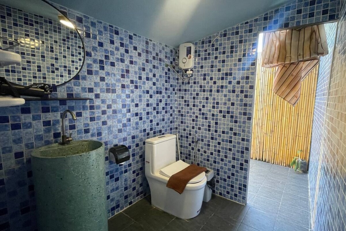 Une salle de bain avec des toilettes, un lavabo et un miroir.