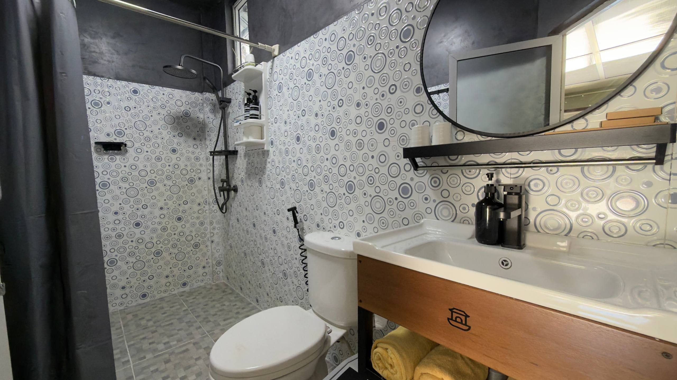 Un bagno con il water, lavandino, specchio e doccia.