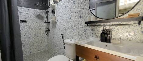 Un bagno con il water, lavandino, specchio e doccia.