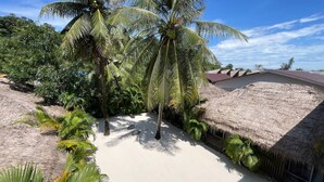 A tropical resort with thatched-roof buildings, palm trees, and a sandy beach. - White Sand Ark Resort (Koh Rong)
