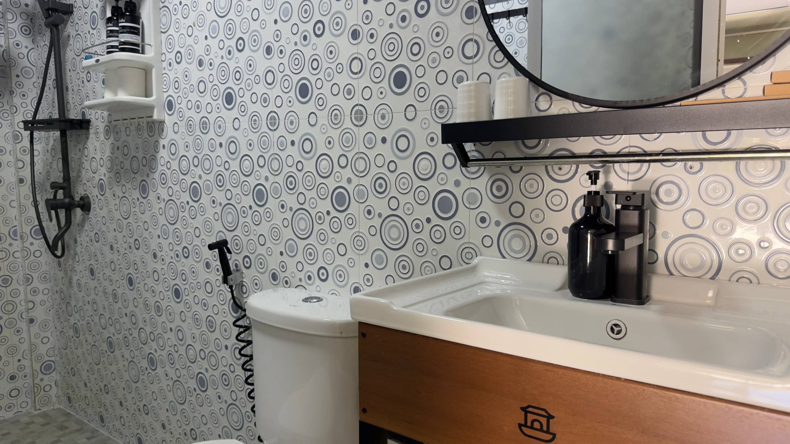 Un baño con lavamanos, espejo y ducha.