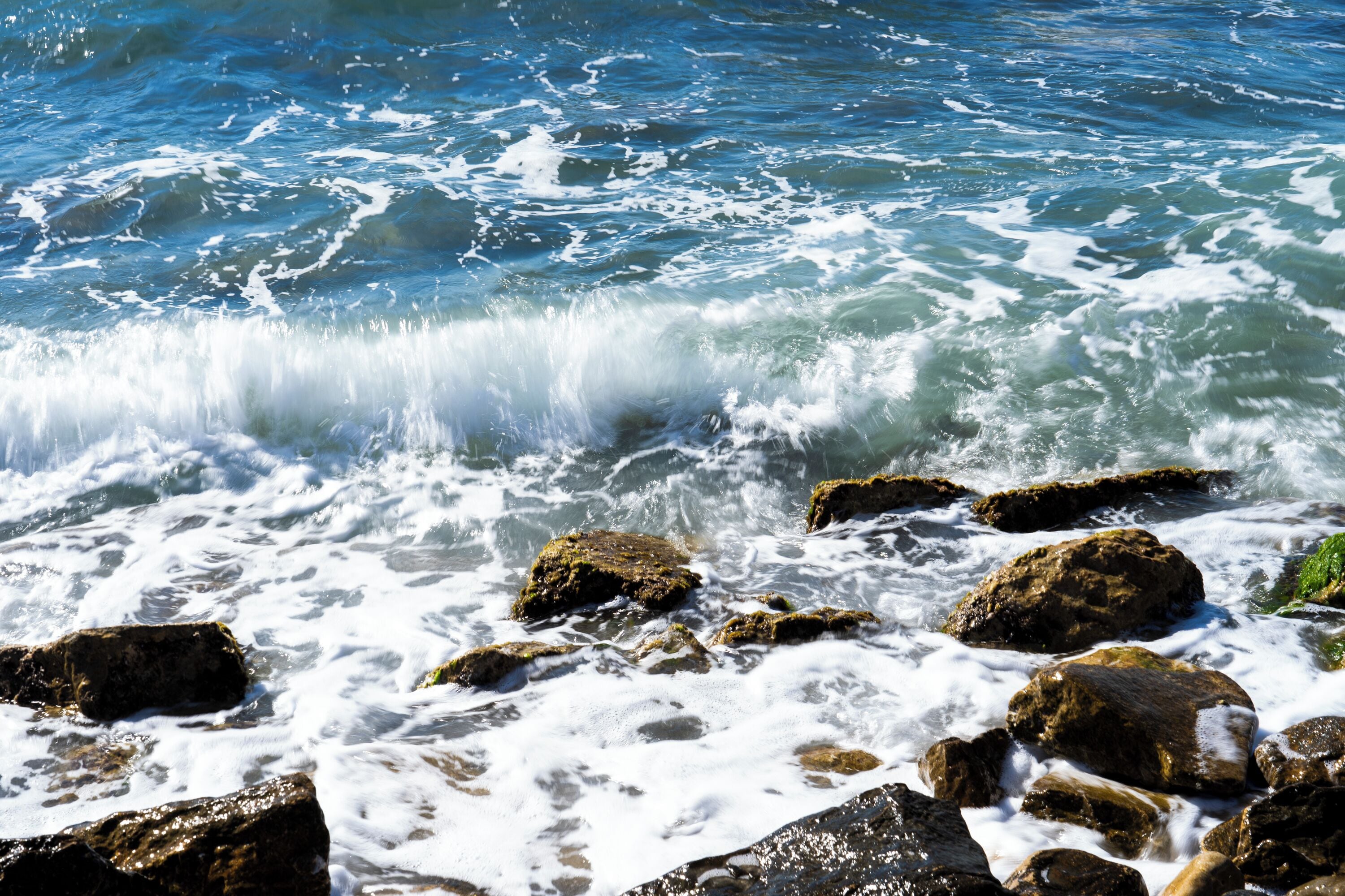 A rocky shoreline with waves crashing against the rocks.
