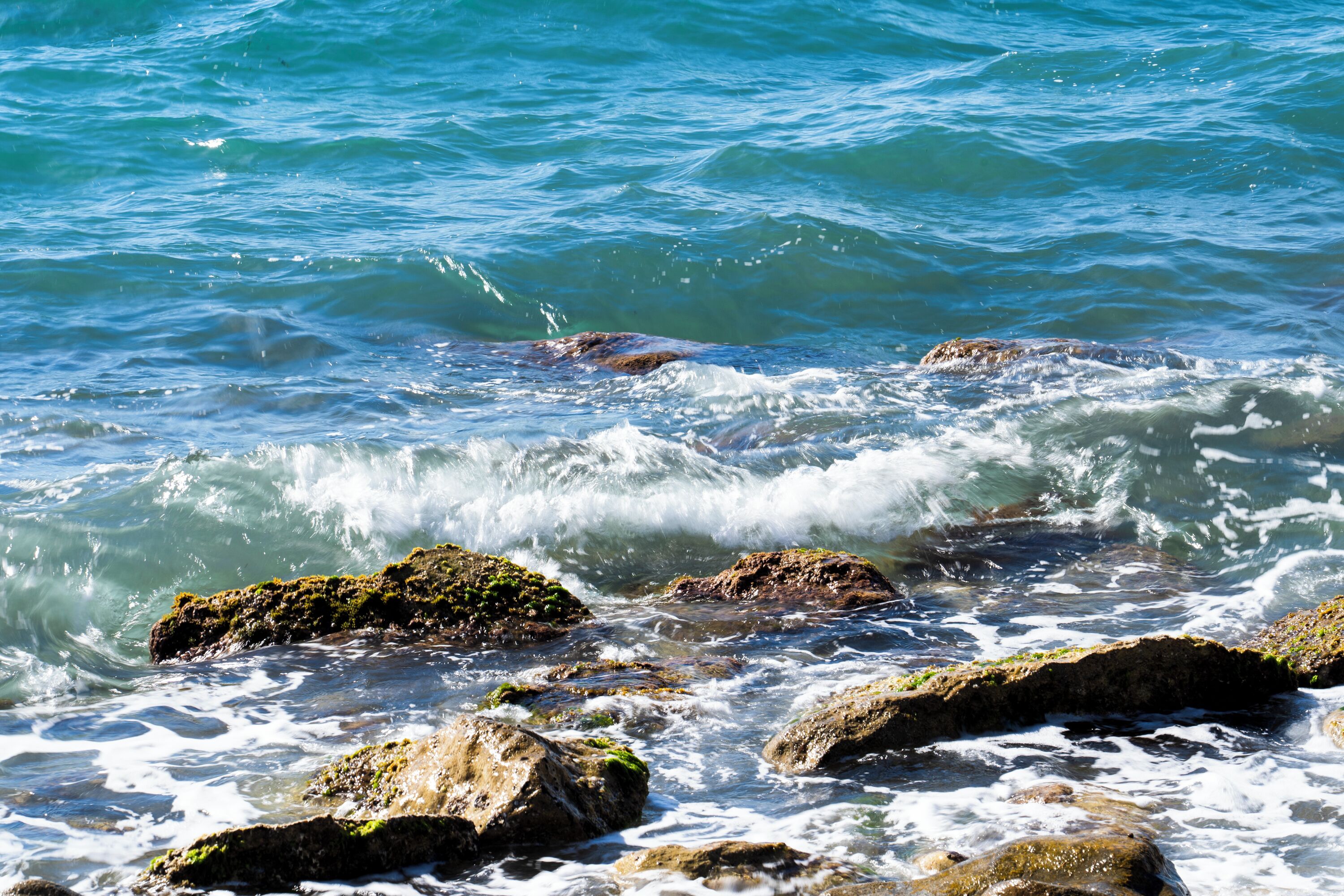 A rocky shoreline with waves crashing against the rocks.
