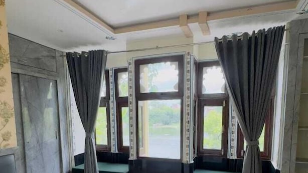 A hotel room with a bed, a window seat, and a ceiling fan. - Hotel Moxa Inn (Udaipur)