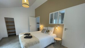 A bedroom with a bed, bedside table, and a wardrobe. - Family house with foosball and heated pool (Soullans)