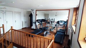 A home gym with treadmills, elliptical machines, and a punching bag. - L'Emmanuella (Isbergues)