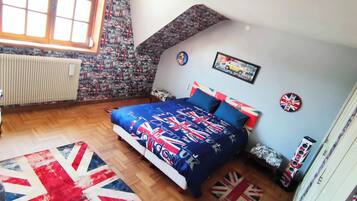 Un dormitorio con cama, ventana, radiador y pared con diseño.