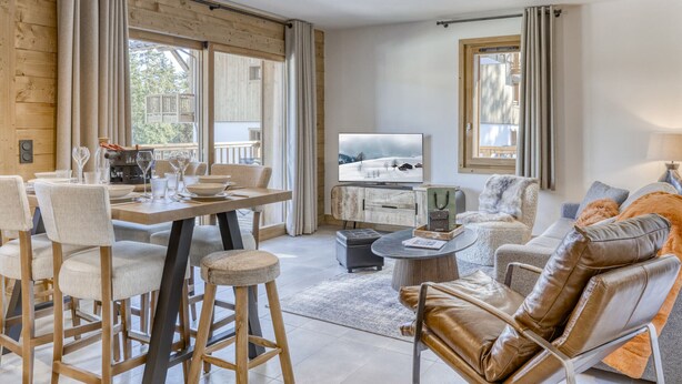 A modern living room with a dining area, wooden walls, large windows, and a television. - Comfortable apartment in Villard-sur-Doron for 6 people with parking (Villard-sur-Doron)