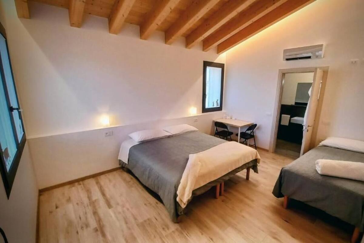 Een slaapkamer met twee bedden, een bureau en een spiegel.
