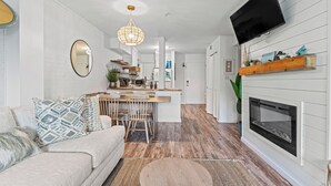Un salon moderne avec un canapé, une table basse et une cheminée.