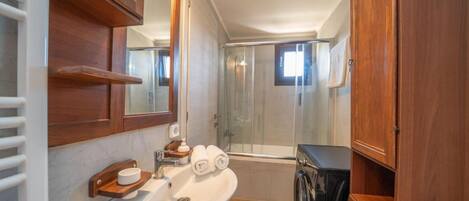 A bathroom with a sink, mirror, wooden cabinets, a shower, and a toilet.