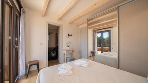 Ein Schlafzimmer mit einem großen Bett, einer Waschmaschine und einer Schiebetür, die auf einen Balkon führt.
