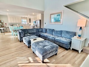 A modern living room with a sectional sofa, a coffee table, and a side table with a lamp. - Oceanview retreat in Oak Island, sleeps 12, perfect for families and a dog! (Oak Island)