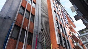 A multi-story building with a mix of brick and concrete facades, large windows, and balconies. - Hotel Excelsior Ltd (Kathmandu)