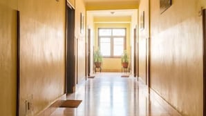 A long, narrow hallway with a polished floor and yellow walls. - Hotel Excelsior Ltd (Kathmandu)