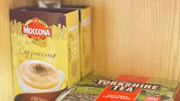 Two boxes of Moccona Cappuccino and Yorkshire Tea on a wooden shelf.