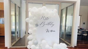 A doorway with a white balloon arch and a sign that reads "Happy Birthday William." - Return to nature (Putty)
