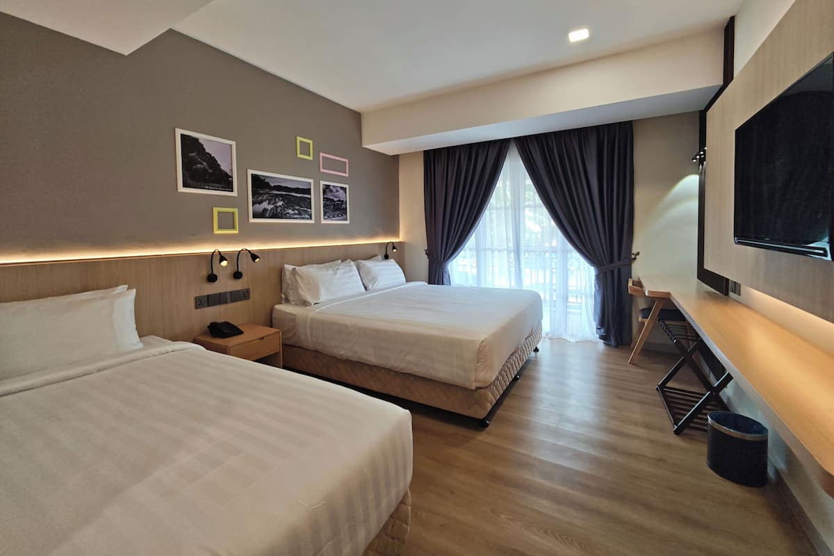 Habitación de hotel con dos camas, televisión, escritorio y ventana con cortinas.
