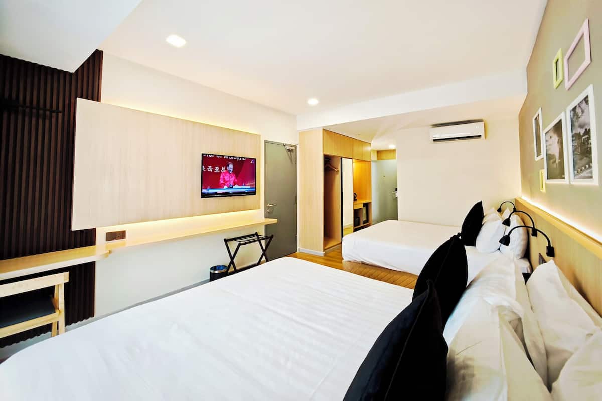 Habitación de hotel con una cama grande, televisión montada en la pared, armario y mesita de noche.
