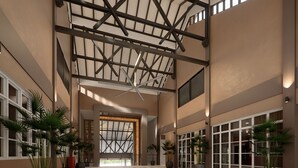 A spacious lobby with high ceilings, large windows, and potted plants. - Raia Beach Resort Port Dickson (Port Dickson)