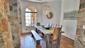 A dining area with a wooden table, benches, and a large window. - Canyon Ridge Oasis (Tucson)