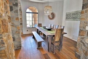 Ein Essbereich mit einem Holztisch, Bänken und einem großen Fenster.