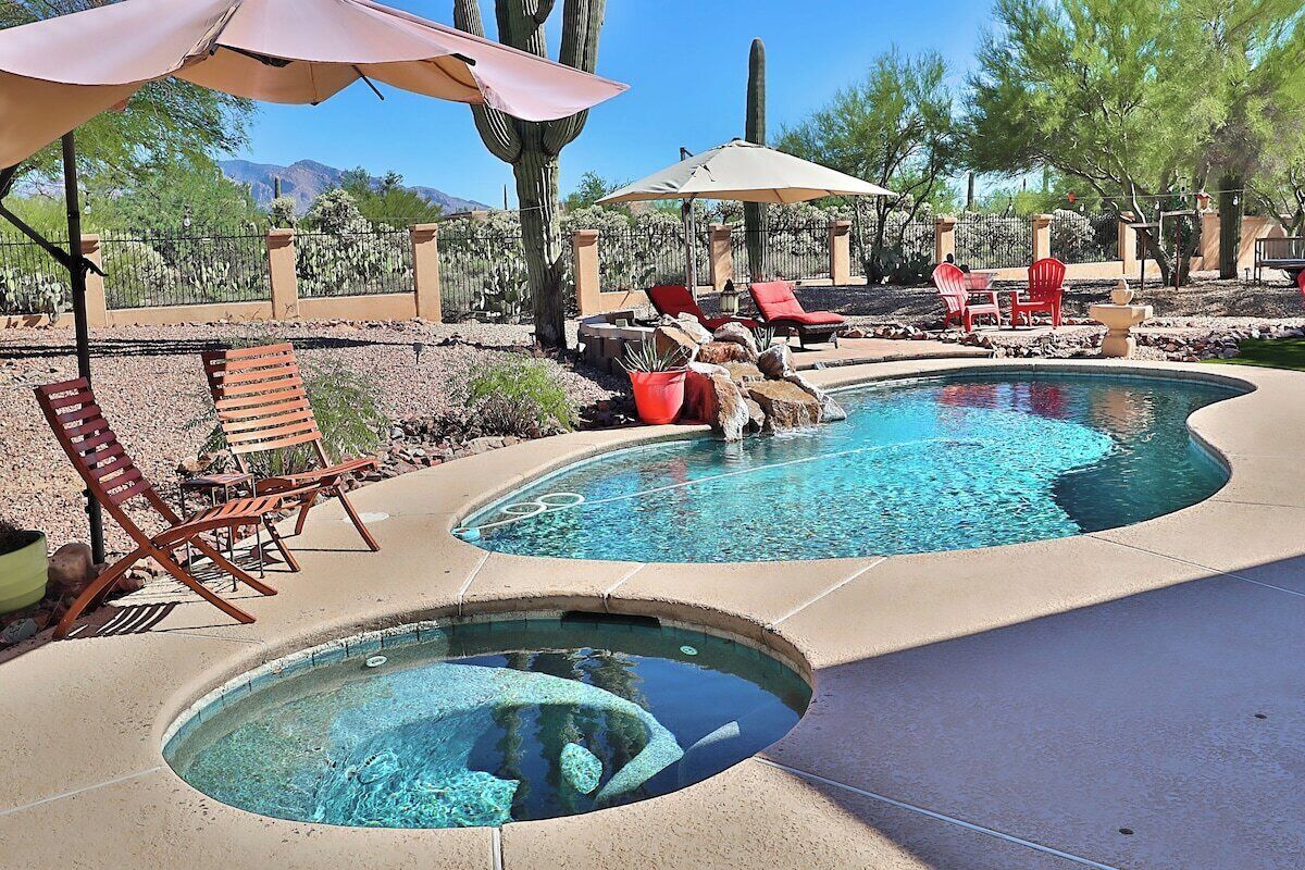 Un espace piscine avec des chaises longues et des parasols.