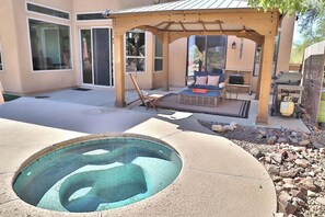 A backyard with a hot tub, patio furniture, and a pergola. - Canyon Ridge Oasis (Tucson)