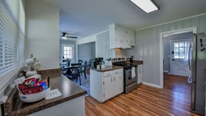 Una cocina con armarios blancos, estufa y refrigerador.