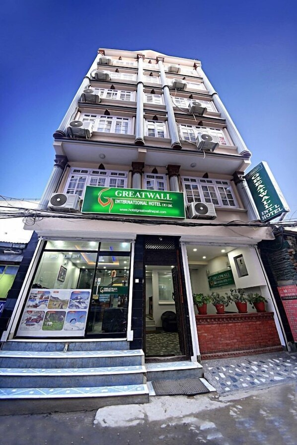 A hotel with a green signboard, multiple floors, and air conditioning units. - Hotel The Greatwall (Kathmandu)