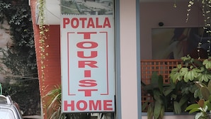 A sign for a tourist home named 'Potala' with a view of a building in the background. - Potala Tourist Home (Kathmandu)