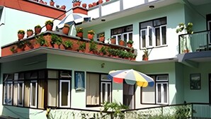 A multi-story building with balconies adorned with potted plants. - Potala Tourist Home (Kathmandu)