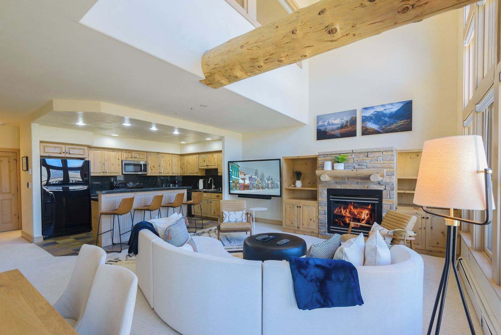 A spacious living area with a modern kitchen, a fireplace, and a comfortable seating arrangement.